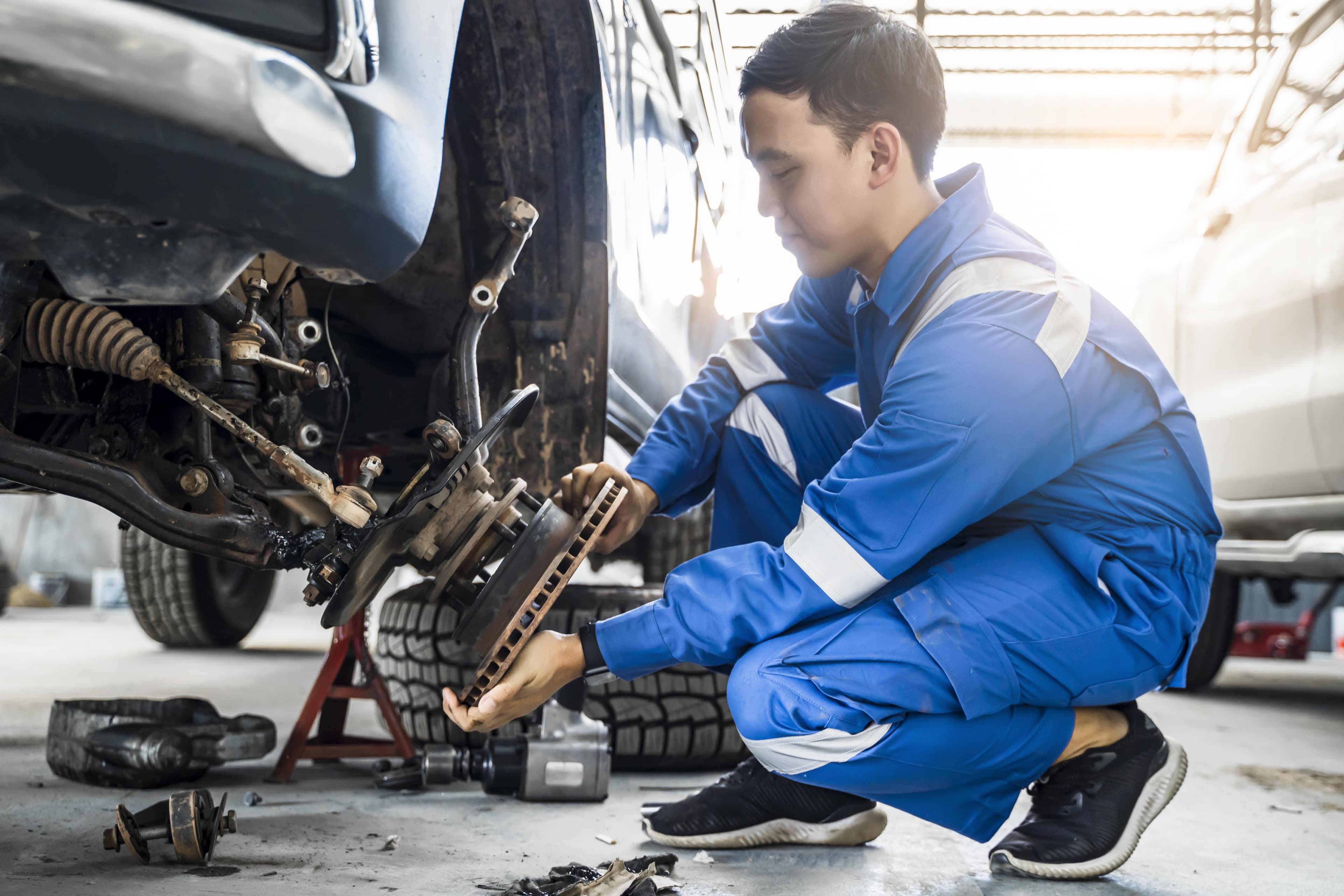 Mechanic at Gibson's Auto Care holding a brake rotor