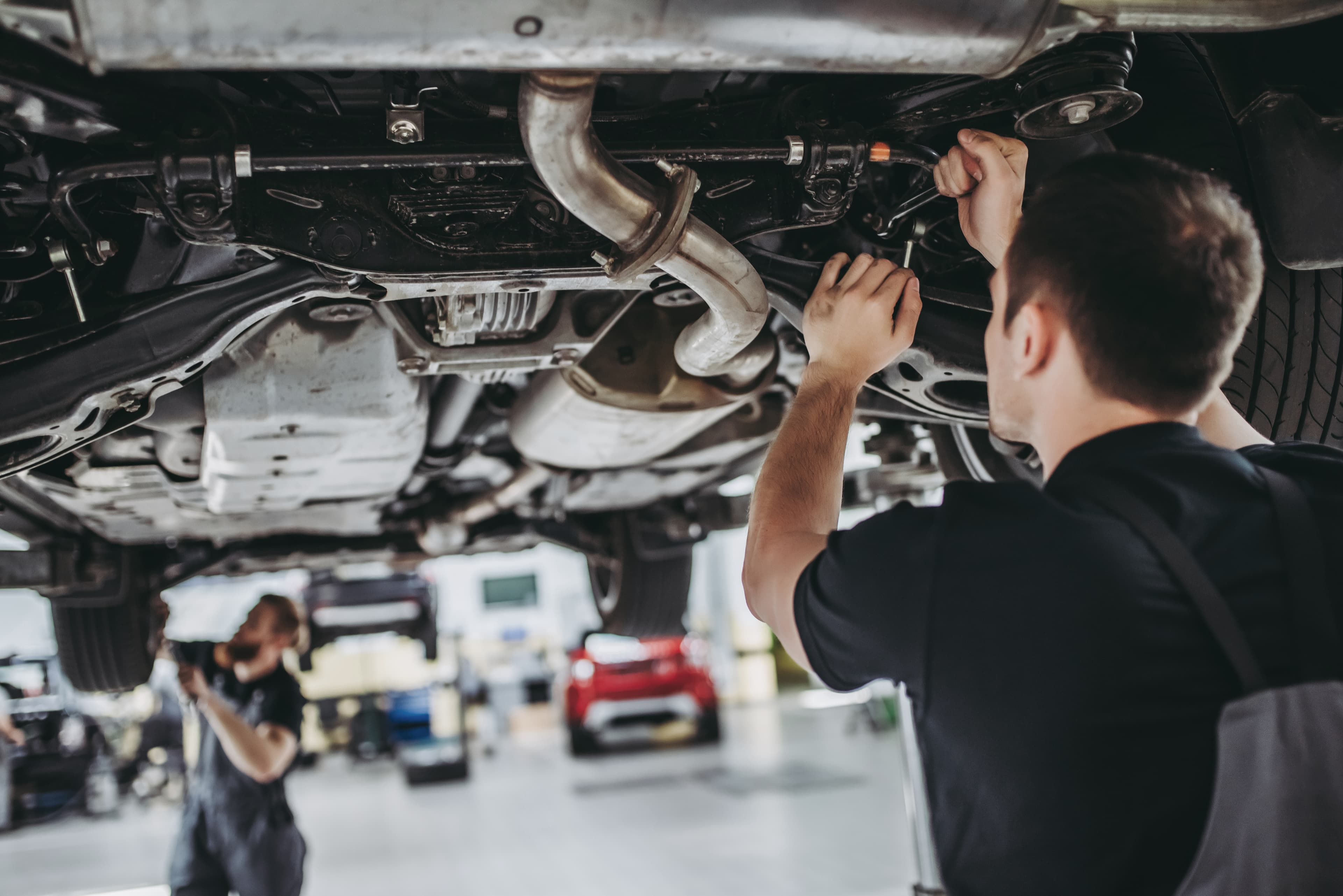 Gibson's Auto Care mechanics working under a lifted vehicle