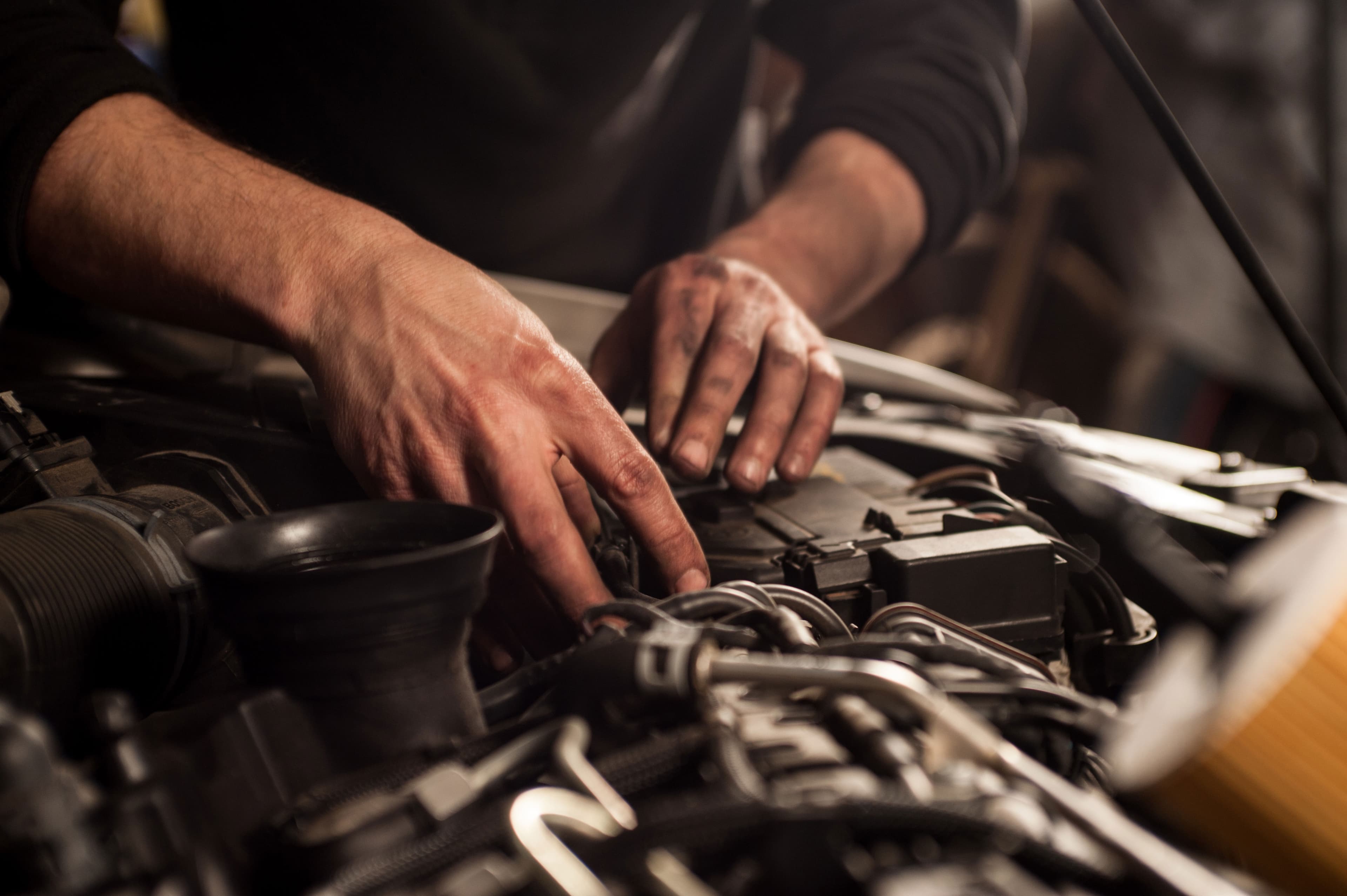Mechanic diagnosing an engine by hand at Gibson's Auto Care